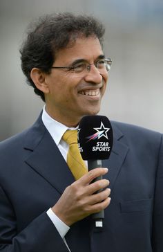 a man in a suit and tie holding a microphone with the star sports logo on it