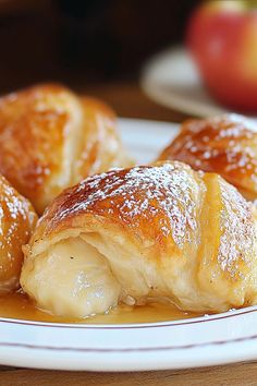 some food is on a white plate with apples in the backgroung and powdered sugar