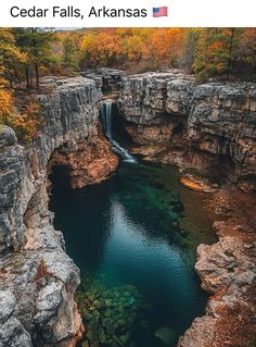 an aerial view of a waterfall in the middle of a river surrounded by rocky cliffs