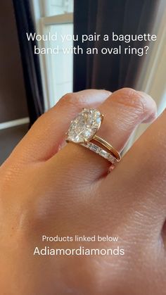 a woman's hand holding a diamond ring with the words would you pair a baguette band with an oval ring?