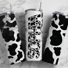 three black and white tumblers sitting on top of a marble counter next to each other