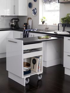 a kitchen with white cabinets and black counter tops