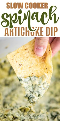 a hand holding a tortilla chip with spinach and artichoke dip