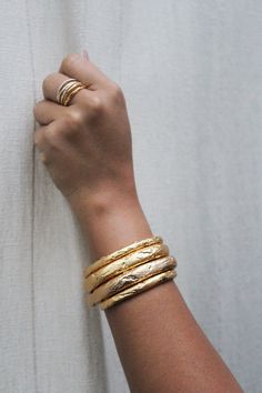 This is fun cuff that is created from wax then cast in brass. The Jennifer cuff is a small but substantial piece of jewelry. The texture is made from acid etching, a completely random process which we so adore. The look is finished with a beautiful 22kt semi matte gold plate. Inside diameter is approx. 2.25" and is slightly adjustable Brass with 22kt gold plate Made with love in the USA Dope Jewelry Accessories, Greek Gifts, Minimalist Fashion Women, Jewellery Diamond, Gems Bracelet, Brass Bracelet, Gold Cuffs, Stacked Jewelry, Bracelet Collection