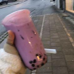 a hand holding up a pink cup with black spots