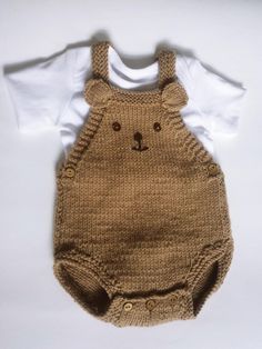 a teddy bear knitted baby romper and t - shirt on a white background