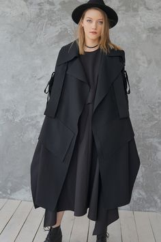 Long Black Wool Coat For Office, Black Cape-style Outerwear For Work, Black Oversized Long Outerwear, Black Long Wool Coat With Pockets, Oversized Long Black Outerwear, Modern Black Wool Coat With Pockets, Black Long Oversized Outerwear, Black Oversized Long Wool Coat, Modern Black Wool Coat With Long Sleeves