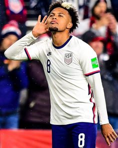 a soccer player holding his hand up in the air