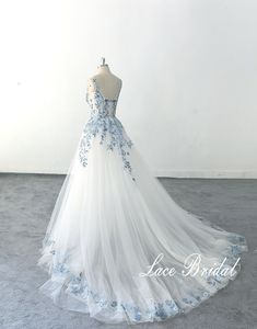 a white and blue wedding dress with flowers on it