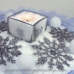 a candle that is sitting in some snow