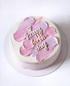 a birthday cake with pink frosting that says happy birthday day on it's side