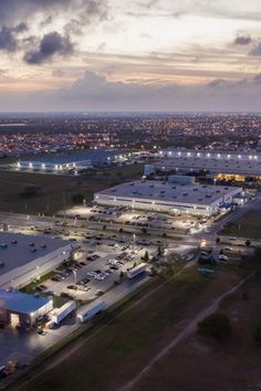 an aerial view of a parking lot and airport at night with cars parked in the lot