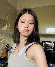 a young woman standing in front of an oven