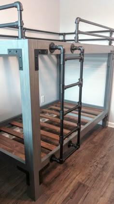 a metal bunk bed frame with wooden slats and pipes on the bottom, against a white wall