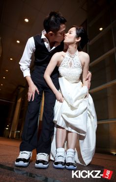 a man and woman kissing in front of a building