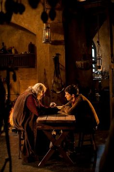 two people sitting at a table in a room