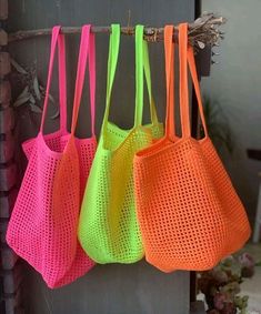 three neon colored bags hanging from a hook