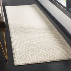 a white rug on the floor next to a window