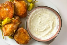 a white plate topped with chicken wings and dip