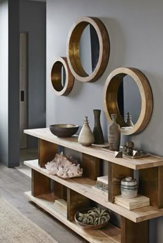 a living room filled with lots of furniture and mirrors on the wall above it's shelves