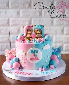 a pink and blue cake with two teddy bears on top