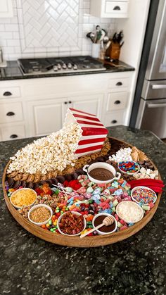 a platter filled with popcorn and candy on top of a kitchen counter