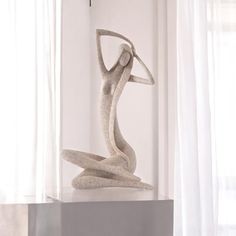 a sculpture sitting on top of a table next to a window