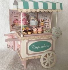 a toy ice cream cart with cupcakes on it