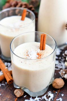 two glasses filled with milk and cinnamon sticks