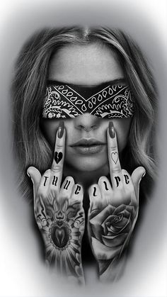 a woman with tattoos covering her eyes and holding two fingers up in front of her face