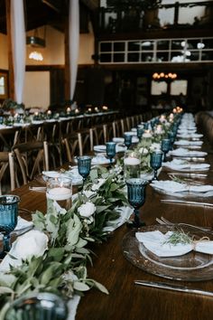 the long table is set with candles and place settings for guests to sit down at