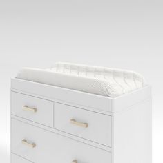 a white dresser with drawers and a baby crib in the bottom drawer is shown