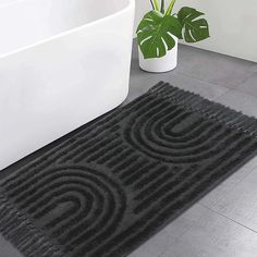 a bath tub sitting next to a black rug