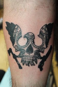 a man with a skull and two crossed swords on his leg is wearing a tattoo