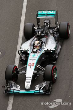 a man driving a race car down a street