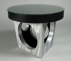 a round glass table with silver and black accents