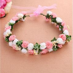 a pink and white flower crown on top of a table