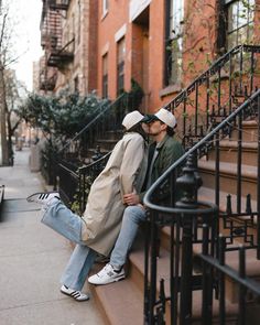 two people kissing on the steps of an apartment building in new york city, ny