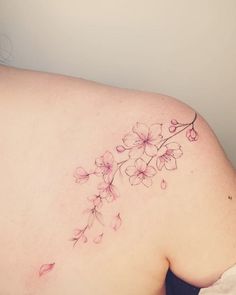 a woman's back with pink flowers on her left side and the upper part of her stomach