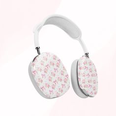 a pair of white headphones with pink flowers on the front and back sides, against a light pink background