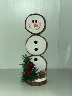 there is a snowman made out of logs on the shelf next to a christmas tree