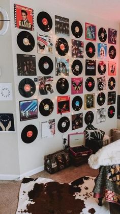 a room with various records on the wall and cowhide rug in front of it