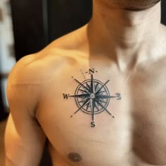 a man with a compass tattoo on his chest