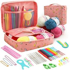 a pink suitcase filled with knitting supplies and crochet hooks