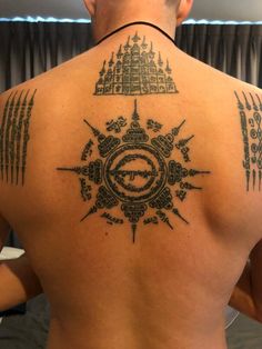 the back of a man with tattoos on his body