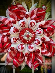 a red and white christmas wreath hanging from a window