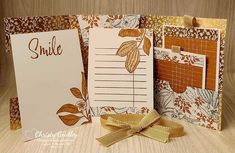 three greeting cards with gold ribbon and matching envelopes, each containing a notepad