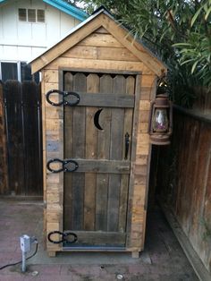 a wooden outhouse sitting next to a fence