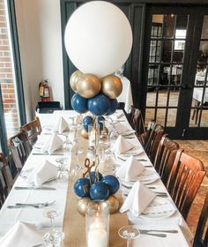 a table set with balloons, candles and napkins