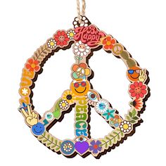 a peace sign made out of flowers and other colorful items is hanging from a string